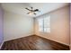 Bright bedroom with wood floors, a ceiling fan, and a window with tree-lined street views at 132 Soaring Sky Ave, Henderson, NV 89011