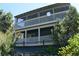 Two-story home with a screened-in porch, white railings, and surrounded by mature trees at 1382 N Trout Canyon Rd, Las Vegas, NV 89124