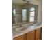 Bright bathroom featuring dual sinks, tiled counters, and a shower over tub with glass doors at 149 Cologne Ct, Henderson, NV 89074