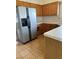 Kitchen with stainless steel refrigerator, tiled countertops, and light wood cabinets at 149 Cologne Ct, Henderson, NV 89074
