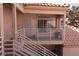 View of front door with landing & railing plus the tile roof above and partial exterior wall at 1900 N Torrey Pines Dr # 225, Las Vegas, NV 89108