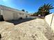Large backyard featuring a private block wall, desert landscaping, and mature palm trees against a clear blue sky at 1906 Double Delight Ave, North Las Vegas, NV 89032
