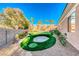Lush backyard featuring a putting green, sand trap, rock garden, and manicured landscaping at 2064 Poetry Ave, Henderson, NV 89052