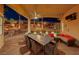 Spacious covered patio with ceiling fan, TV, outdoor dining table and landscaped backyard at 2064 Poetry Ave, Henderson, NV 89052