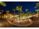 Night view of a home's backyard featuring desert landscaping, palm trees, and an outdoor seating area at 2064 Poetry Ave, Henderson, NV 89052