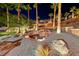 A beautifully landscaped backyard featuring a rock waterfall, palm trees, and stone at 2064 Poetry Ave, Henderson, NV 89052