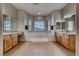 Large bathroom featuring a tub under a picture window, dual sinks, and tile floors at 2064 Poetry Ave, Henderson, NV 89052