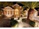Inviting home exterior with manicured landscaping, arched entryway, stone accents, and warm lighting at 2064 Poetry Ave, Henderson, NV 89052