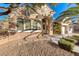 Charming stucco home with stone accents, arched entryway, desert landscaping, and a well-manicured lawn at 2064 Poetry Ave, Henderson, NV 89052