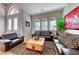 Comfortable living room with Zebra print rug, leather sofas, and arched front windows at 2064 Poetry Ave, Henderson, NV 89052