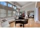 Elegant living space with a grand piano, high ceilings, large windows, and an adjacent office at 2064 Poetry Ave, Henderson, NV 89052