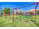 Community playground with swings and covered play area on artificial turf surrounded by landscaping at 2064 Poetry Ave, Henderson, NV 89052