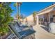 Landscaped backyard with lounge chairs, pool with safety fence and mature trees, perfect for relaxing at 225 Deer Crossing Way, Henderson, NV 89012