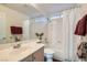 Clean bathroom featuring a shower-tub combo, neutral cabinets, sink, and decorative accents at 225 Deer Crossing Way, Henderson, NV 89012