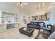 Open-concept living room with a large leather sofa, tile floors, and a view of the kitchen at 225 Deer Crossing Way, Henderson, NV 89012