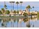 Picturesque lakefront view with palm trees, community center, and tranquil water reflections at 2632 Starfish Ct, Las Vegas, NV 89128