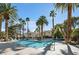 Inviting community pool surrounded by mature palm trees and lush landscaping creating a private retreat at 2632 Starfish Ct, Las Vegas, NV 89128