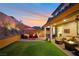 Serene backyard with covered patio, outdoor furniture, artificial turf, and tasteful landscaping at 27 Parco Fiore Ct, Henderson, NV 89011