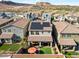 This aerial backyard view showcases a covered patio, green lawn, and mountain views at 27 Parco Fiore Ct, Henderson, NV 89011