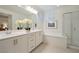 Modern bathroom with a double vanity, soaking tub, and glass-enclosed shower, offering a spa-like experience at 27 Parco Fiore Ct, Henderson, NV 89011