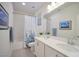 Modern bathroom features double sinks, white cabinets and a shower over the tub at 27 Parco Fiore Ct, Henderson, NV 89011