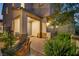 Inviting covered entrance with seating, decorative landscaping, and exterior lighting at 27 Parco Fiore Ct, Henderson, NV 89011