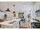 Modern kitchen with white cabinetry, stainless steel appliances, and a seamless view into the living area at 27 Parco Fiore Ct, Henderson, NV 89011