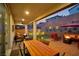 Relaxing covered patio with a dining table, a fire pit, and a view of the landscaped yard at 27 Parco Fiore Ct, Henderson, NV 89011