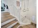 Elegant staircase with white railings and wood stairs illuminated by modern pendant lights, leading to the second floor at 27 Parco Fiore Ct, Henderson, NV 89011