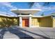 Striking mid-century modern home with an orange door, stone accents, and unique architectural details at 3586 Spencer St, Las Vegas, NV 89169
