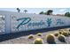 Community signage with mid-century modern design and lush desert landscape with cacti at 3586 Spencer St, Las Vegas, NV 89169