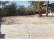 Spacious backyard with mature trees, open area, and concrete patio space at 3711 Southern Light Dr, Las Vegas, NV 89115