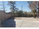 Large backyard with a mix of concrete and open land surrounded by mature trees and a block wall at 3711 Southern Light Dr, Las Vegas, NV 89115