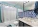 Cozy bathroom features a shower-tub combo, decorative tile accent, and a vanity with a solid surface counter at 3994 Ridgewood Ave, Las Vegas, NV 89120