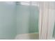 Shower tub combo with mint green tiling and white shower curtain at 3994 Ridgewood Ave, Las Vegas, NV 89120