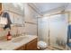 Bathroom with tiled walls, shower, and sink with wood cabinets at 3994 Ridgewood Ave, Las Vegas, NV 89120