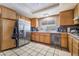 Bright kitchen featuring light wood cabinets, stainless steel refrigerator and tile flooring at 3994 Ridgewood Ave, Las Vegas, NV 89120
