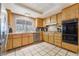 Traditional kitchen with light wood cabinets, tile floor, stainless appliances, and a window above the sink at 3994 Ridgewood Ave, Las Vegas, NV 89120
