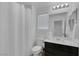 Well-lit bathroom features dark vanity, mirror, toilet, and shower with curtain at 406 Misterioso St, Henderson, NV 89011