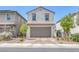 Charming stucco home featuring a two-car garage, brick driveway, and manicured landscaping at 406 Misterioso St, Henderson, NV 89011