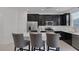 Well-lit kitchen with dark cabinets, stainless steel appliances, white countertops, and island seating at 406 Misterioso St, Henderson, NV 89011
