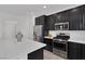Bright kitchen with stainless steel appliances, dark cabinets, and white countertops at 406 Misterioso St, Henderson, NV 89011