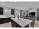 Open-concept kitchen with dark cabinetry, stainless steel appliances, island with seating, and view into the living area at 406 Misterioso St, Henderson, NV 89011