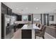 Bright open kitchen featuring stainless steel appliances, dark cabinets, and a large island with seating at 406 Misterioso St, Henderson, NV 89011