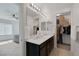 Elegant bathroom features double sinks, a vanity with dark wood cabinets, and a large walk-in closet at 406 Misterioso St, Henderson, NV 89011