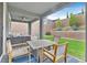 Inviting covered patio area with a dining table, chairs, and nice landscaping at 4163 Peaceful Meadow St, Las Vegas, NV 89135