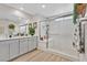 Modern bathroom features double vanity, and glass enclosed shower with bench at 4163 Peaceful Meadow St, Las Vegas, NV 89135