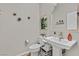 Stylish half-bathroom with pedestal sink, decorative mirror, and modern accents at 4163 Peaceful Meadow St, Las Vegas, NV 89135