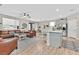 Open-concept living area with wood floors, modern furnishings, a large kitchen island, and plenty of natural light at 4163 Peaceful Meadow St, Las Vegas, NV 89135