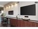 Modern living room featuring a large screen TV, a decorative fireplace, and stylish wooden built-in cabinets for storage at 4381 W Flamingo Rd # 24304, Las Vegas, NV 89103